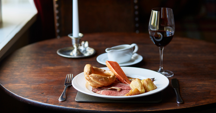 View of a sunday dinner on a plate and glass of wine at Headlam Hall Hotel